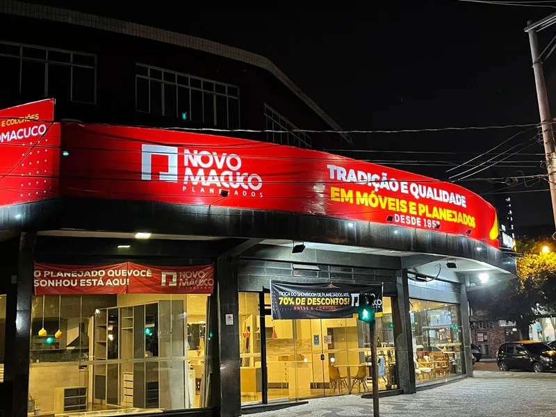 Fachada com luminoso em ACM, lona com reforço e ilhós e adesivo recortado para a Novo Macuco Móveis — Cromatica Comunicação Visual, Santos/SP